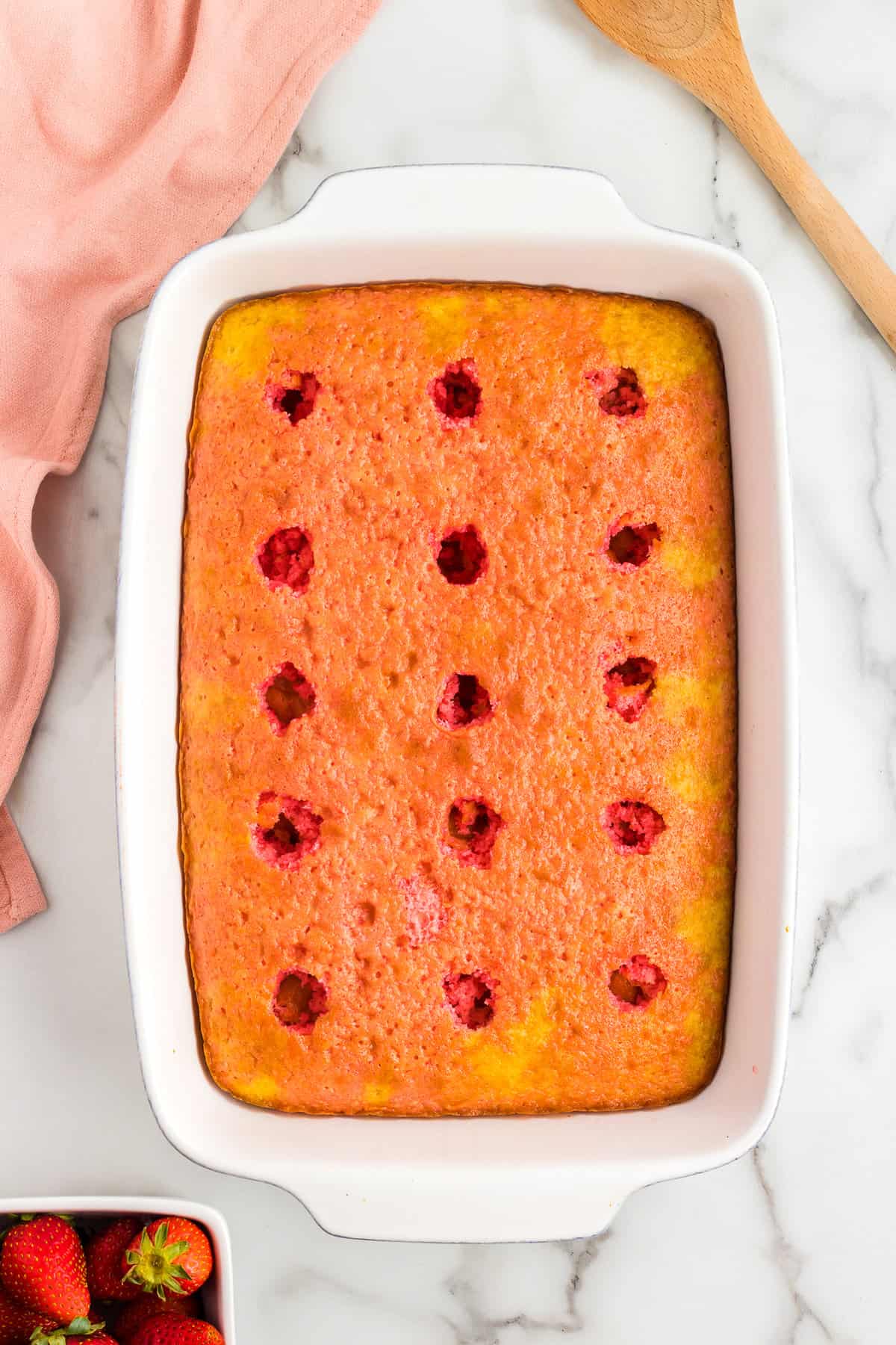 Poke cake with strawberry jello poured over it