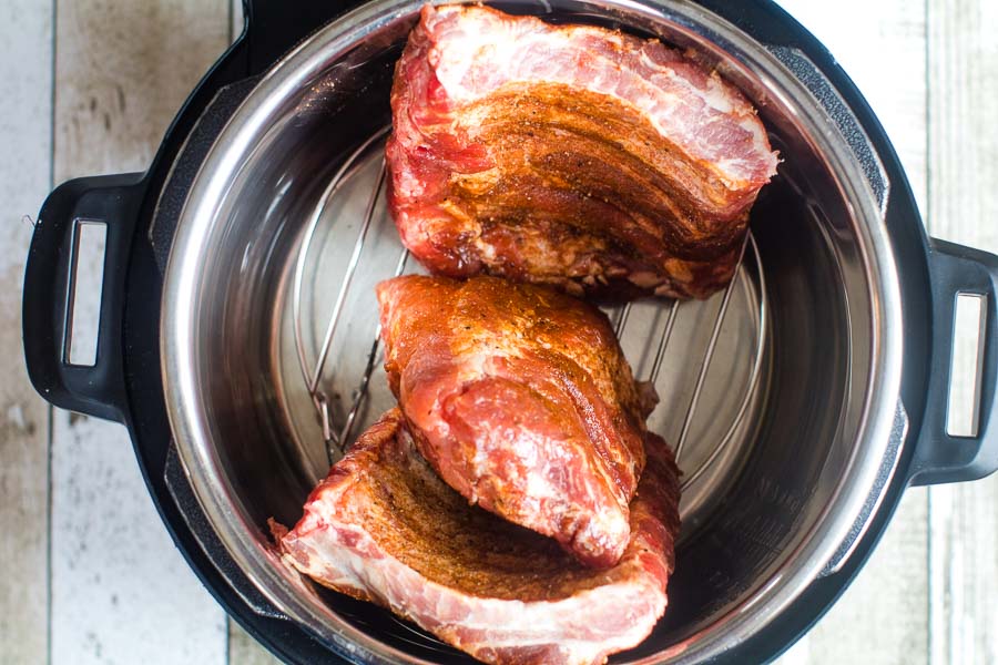 Overhead image of a rack of baby back ribs cut into three sections in an Instant Pot.