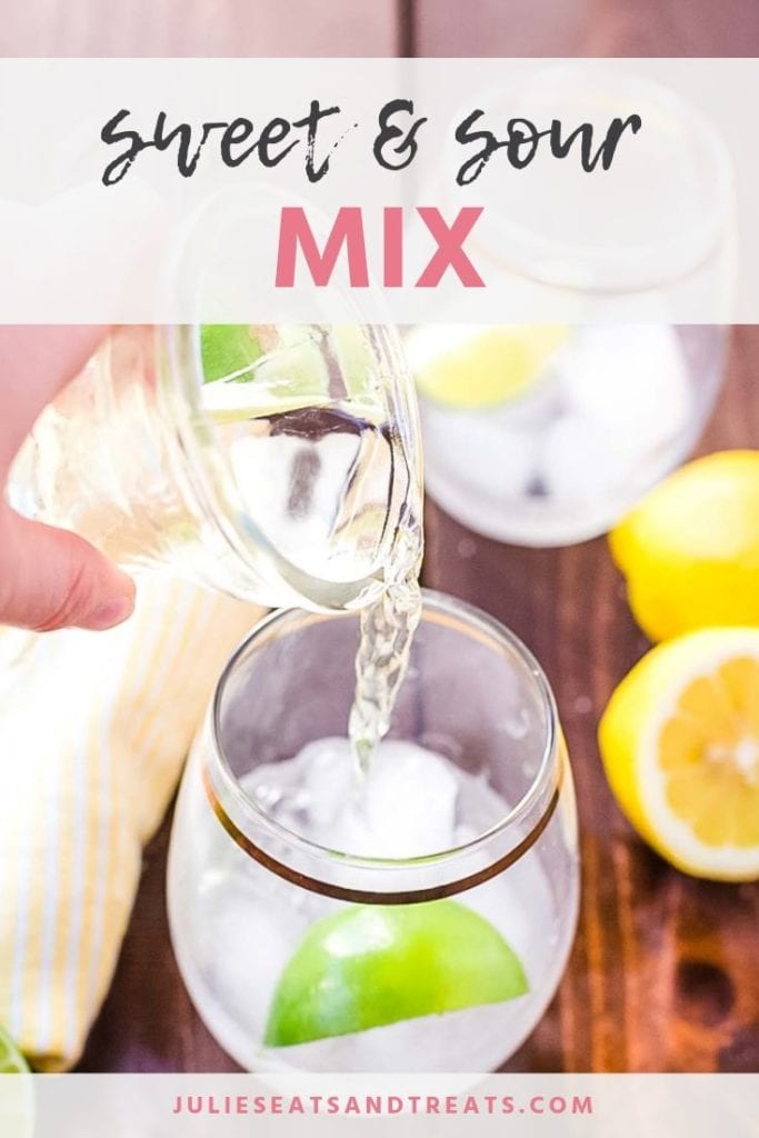 Sweet and sour mix being poured into a glass with ice and a lime wedge