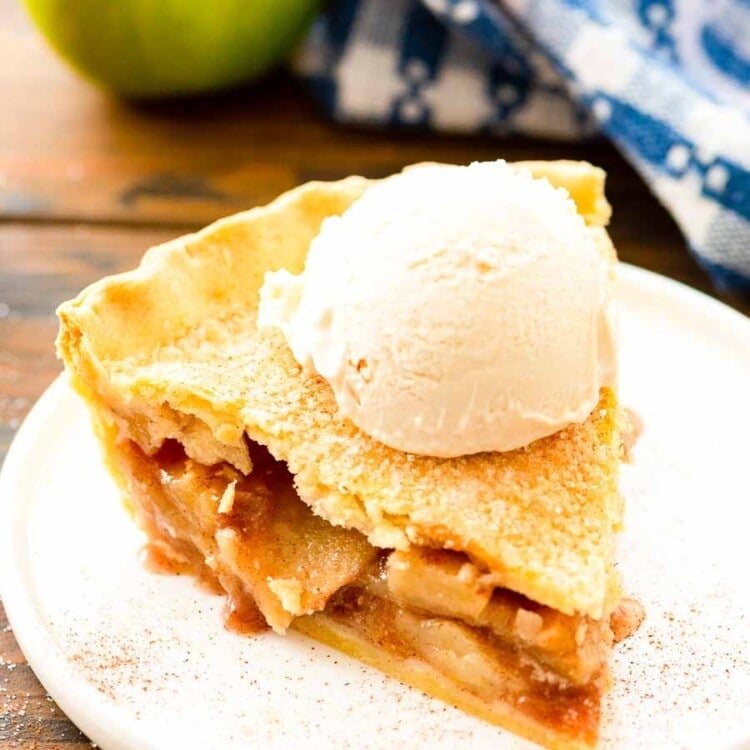 Slice of Apple Pie topped with a scoop of vanilla ice cream