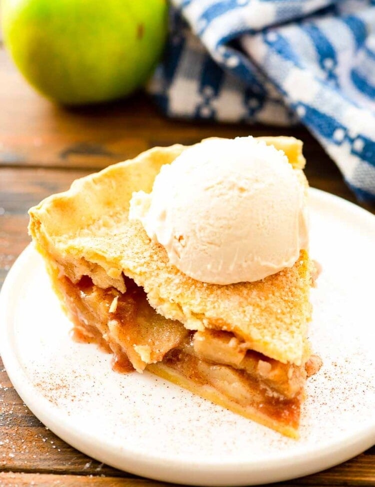 Slice of Apple Pie topped with a scoop of vanilla ice cream