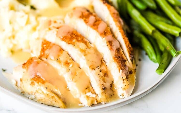 Crock Pot Turkey Breast Slices on plate with green beans and gravy