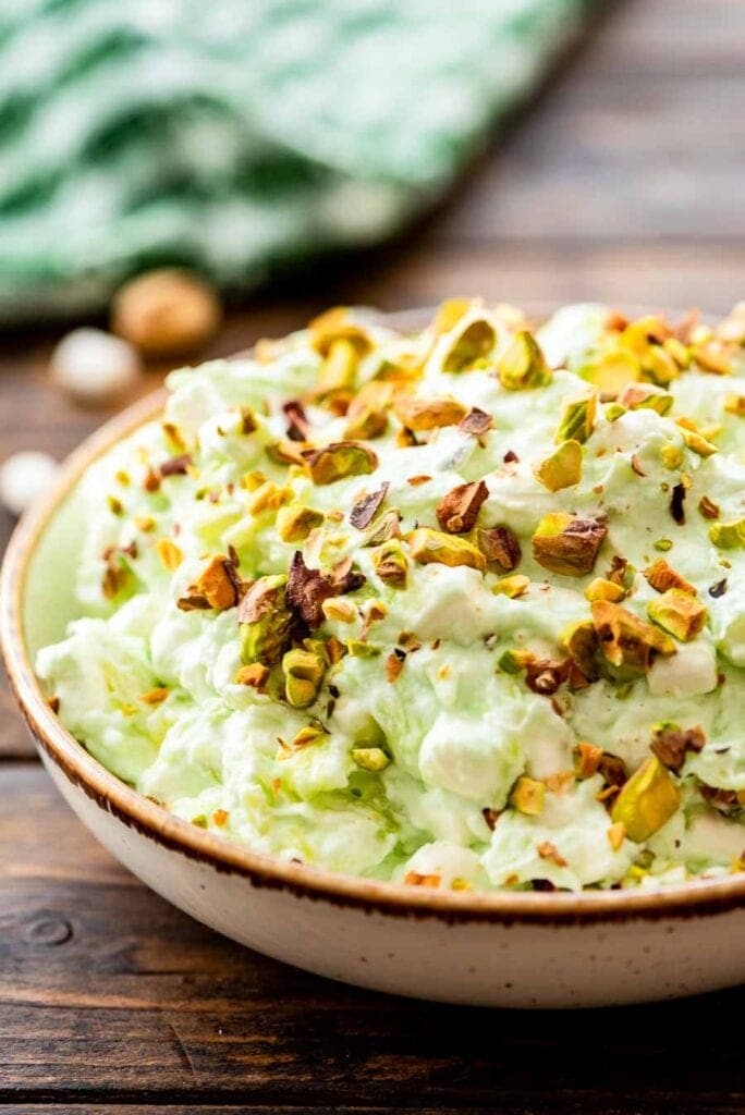 Close up image showing bowl of watergate salad topped with chopped pistachios