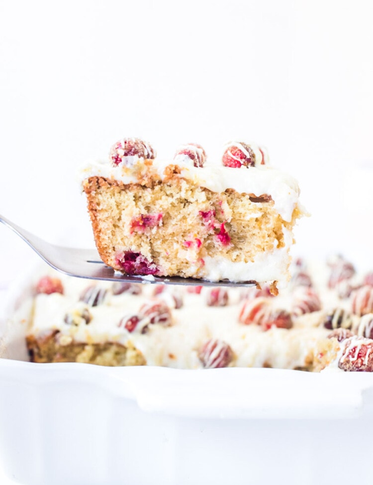 Piece of Cranberry Cake on spatula being lifted out of a baking dish