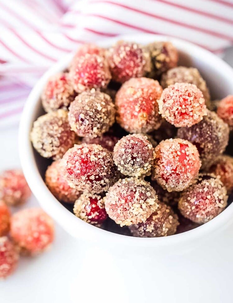 bowl of sugared cranberries with a red and white striped napkin in the background