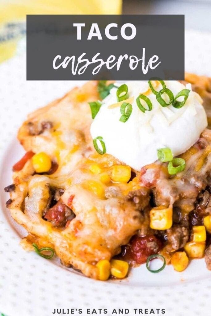 Taco casserole topped with sour cream on a white plate