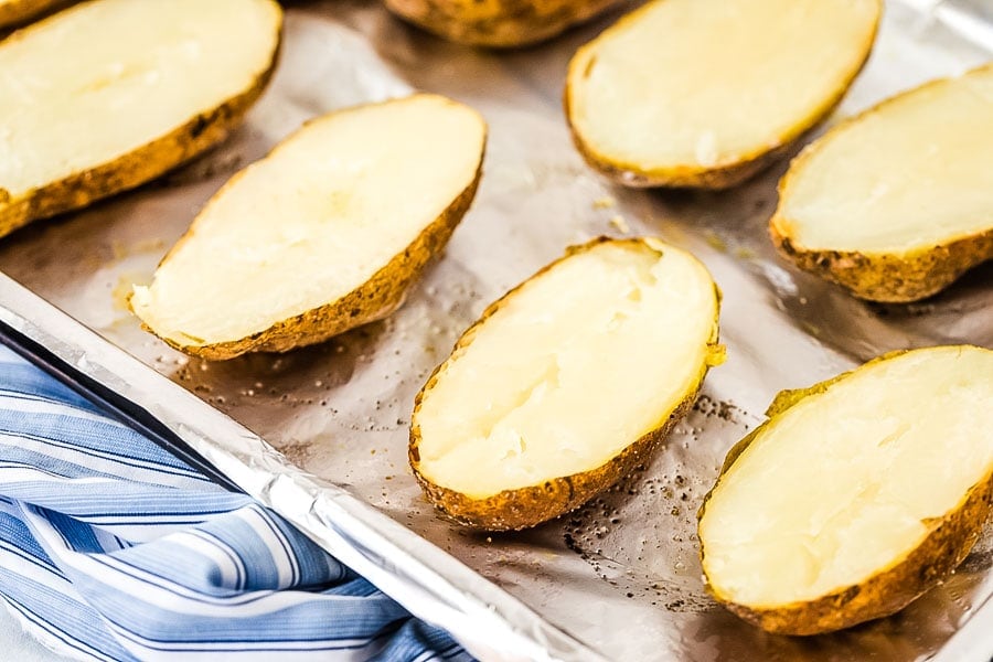 Potatos on baking sheet cut in half