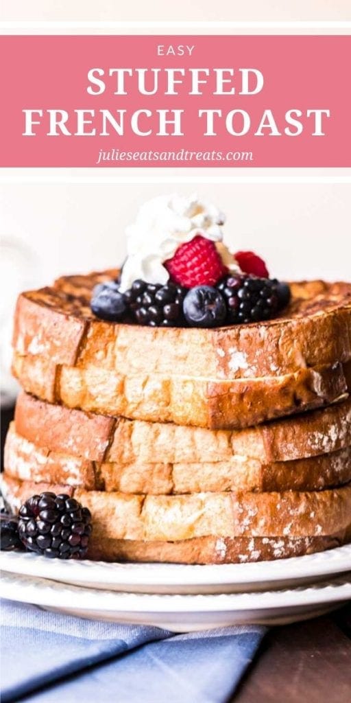 Stack of stuffed french toast topped with whipped cream and berries on a white plate