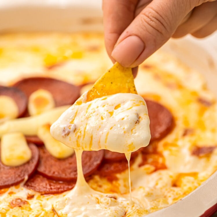 Chip dipping pizza dip out of pie plate.