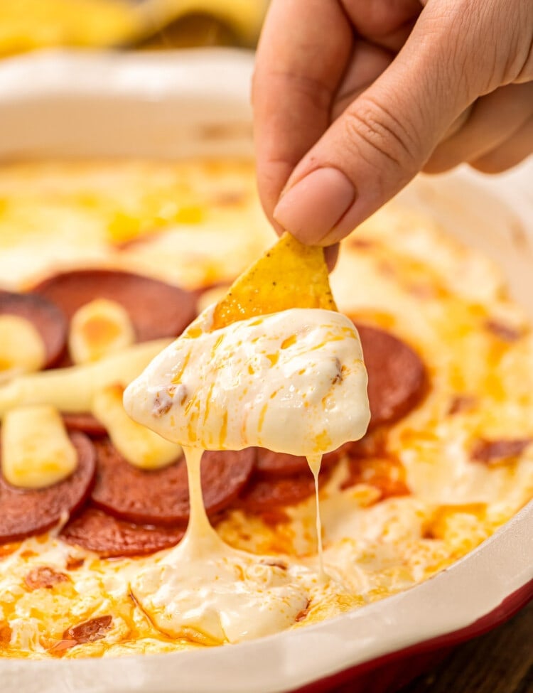 Chip dipping pizza dip out of pie plate.