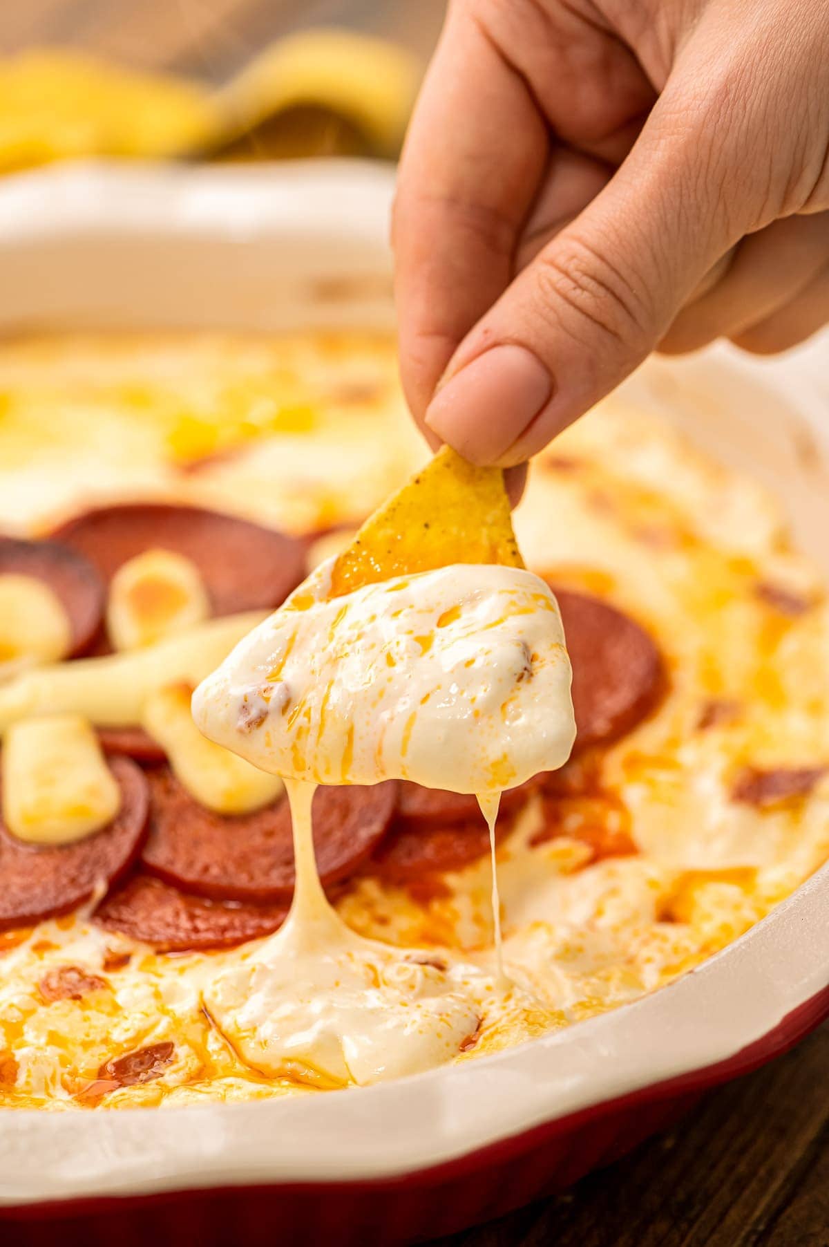 Chip dipping pizza dip out of pie plate.
