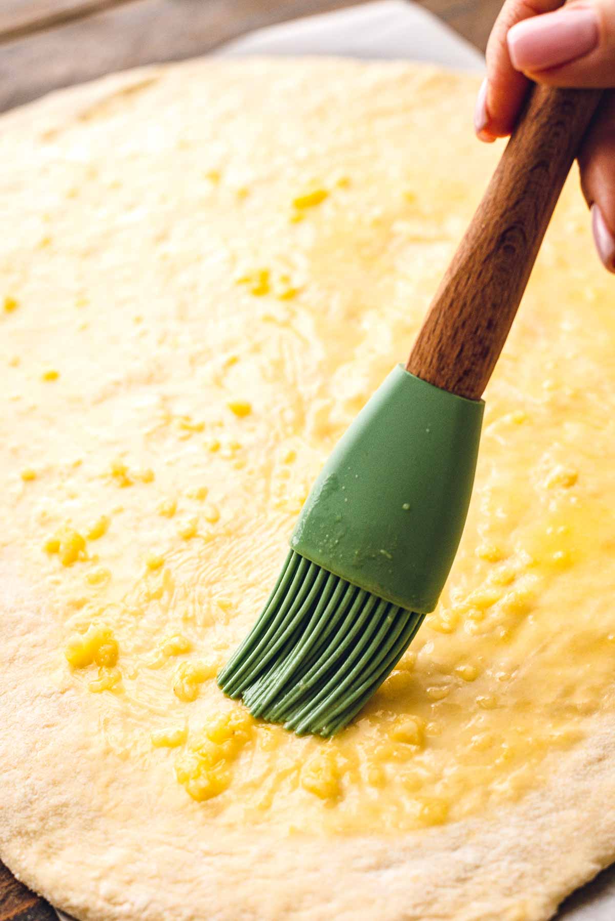 Brushing butter on pizza dough