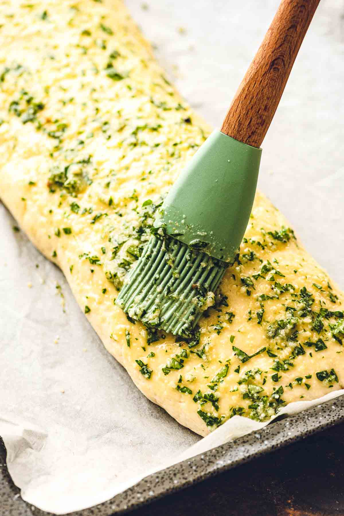 Brushing top of stromboli with herb butter