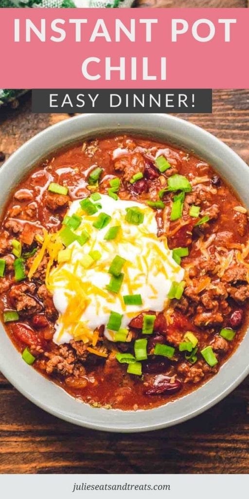 chili in a bowl topped with sour cream, shredded cheese, and chives