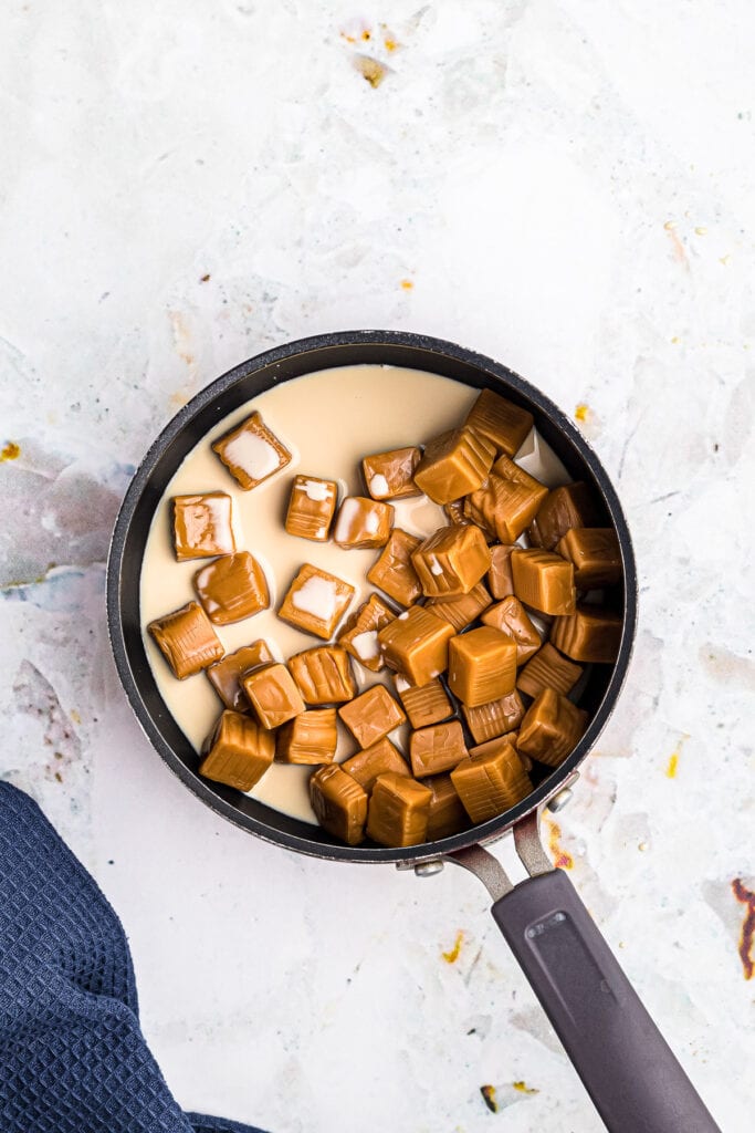 Caramel and evaporated milk in saucepan before melting together.