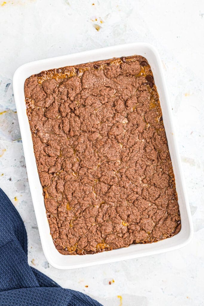 Overhead image of a white baking dish with baked chocolate caramel brownies in it.