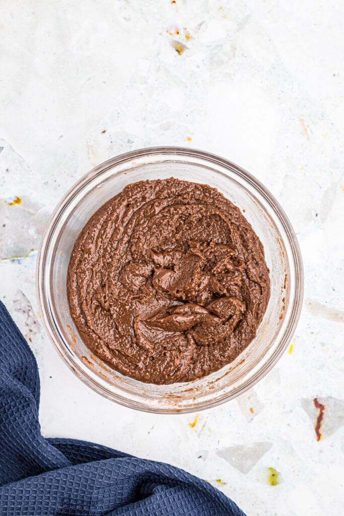 Overhead image of glass bowl with ingredients for brownies after mixing