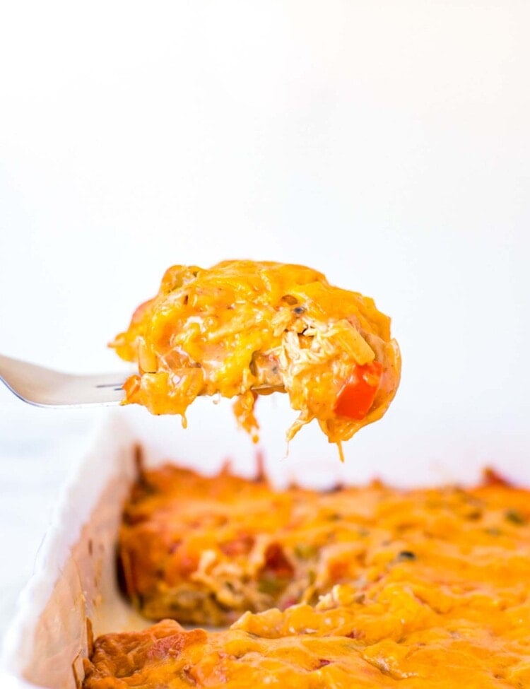 a bite of king ranch casserole on a fork over the top of the casserole