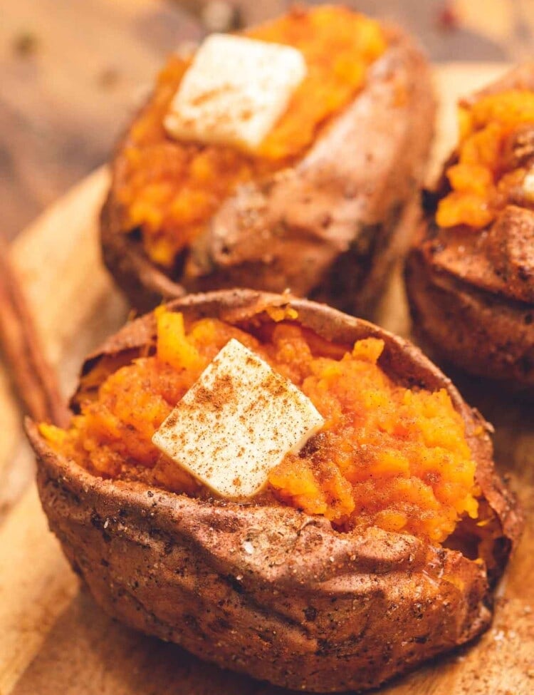 Air Fryer Baked Sweet Potato cut open and topped with butter and sprinkled with cinnamon