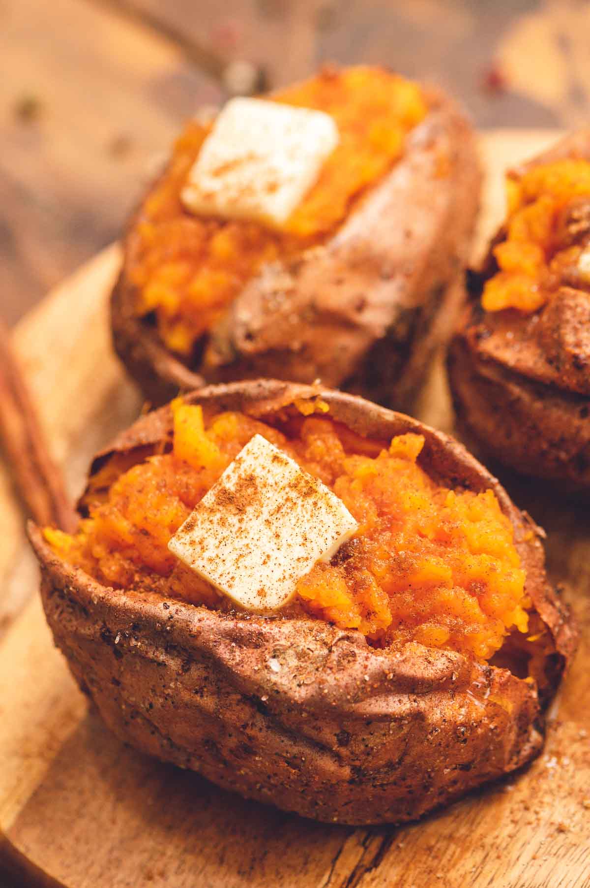 Air Fryer Baked Sweet Potato cut open and topped with butter and sprinkled with cinnamon