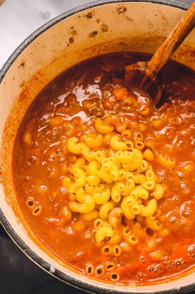 Noodles added to a Pot of goulash ingredients