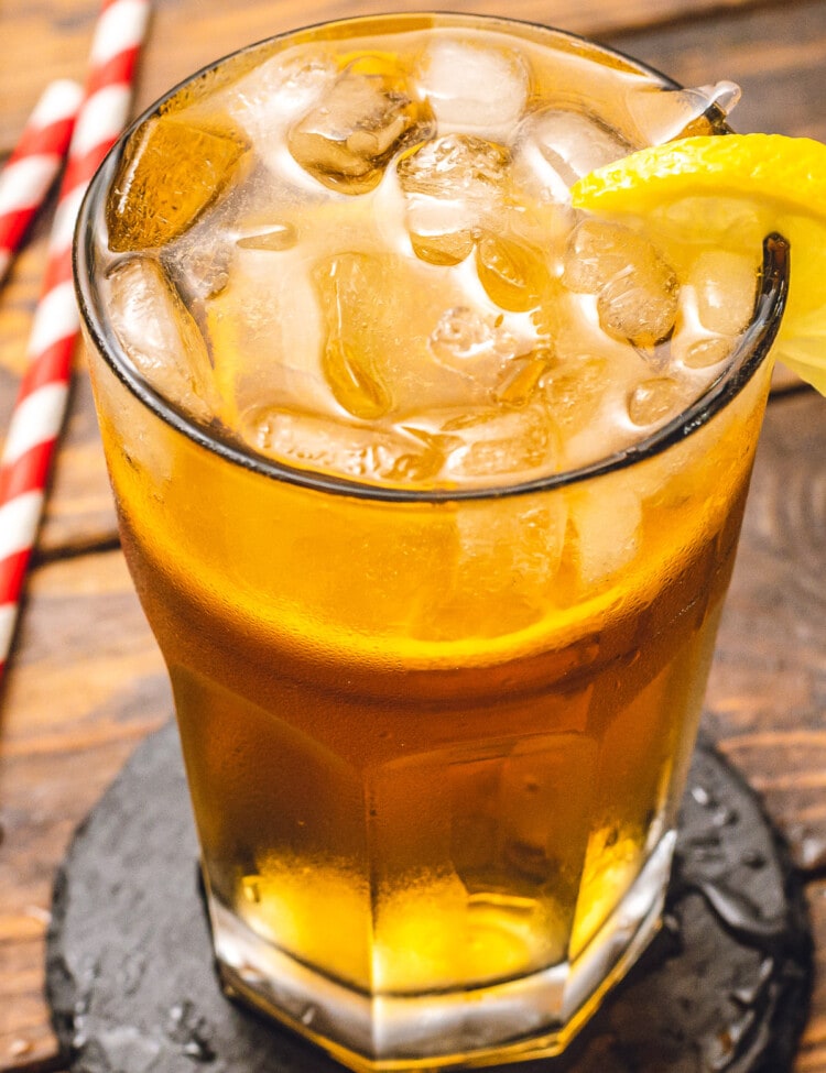 Glass with ice and john daly cocktail garnished with lemon slice