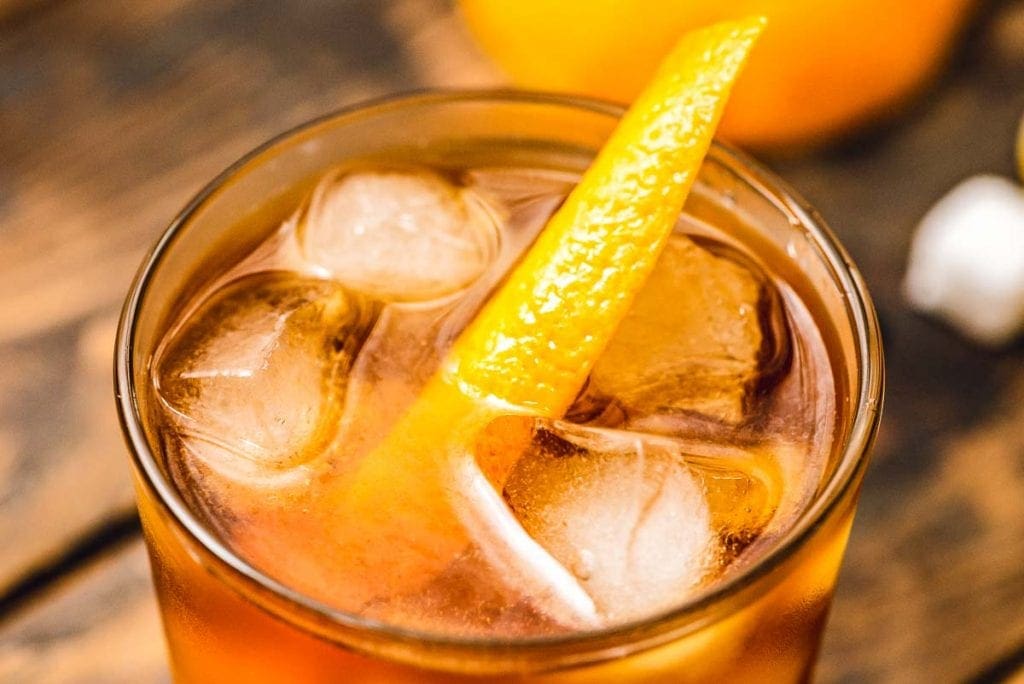 Top of a glass with old fashioned cocktail and orange peel