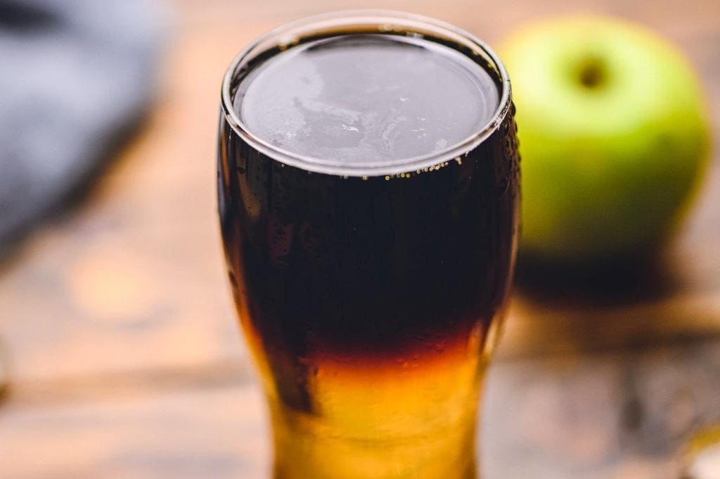 Pint glass with cider on the bottom and lager on the top