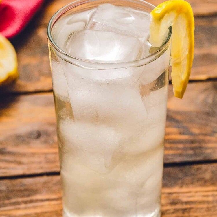 Tom collins in glass with ice and a lemon slice