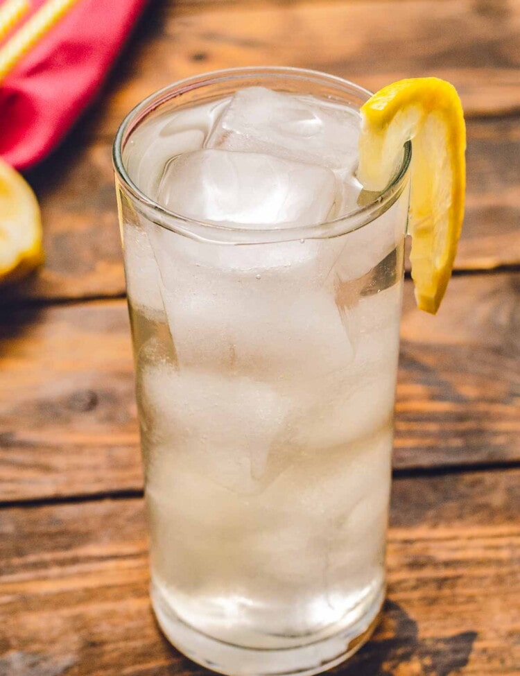 Tom collins in glass with ice and a lemon slice