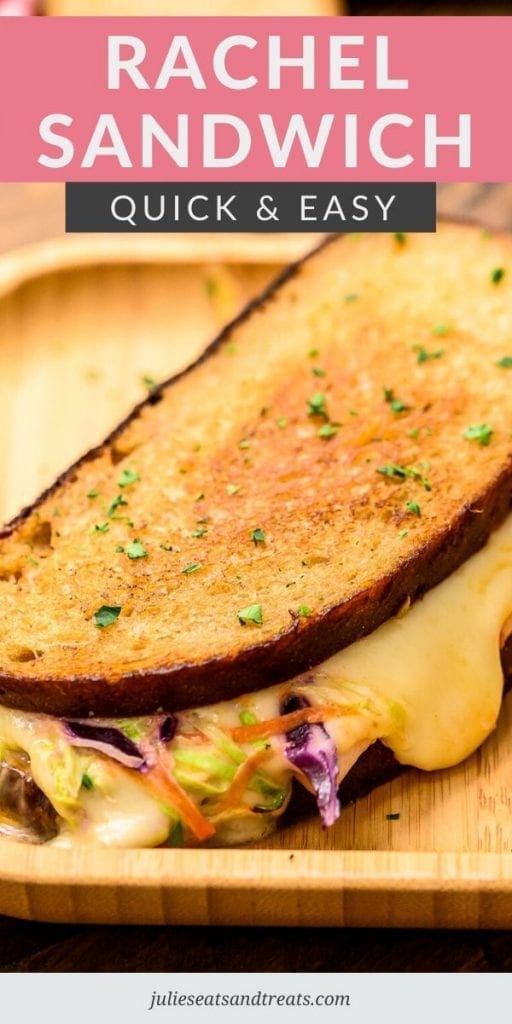 Rachel Sandwich with cheese oozing out of the side on a wood plate