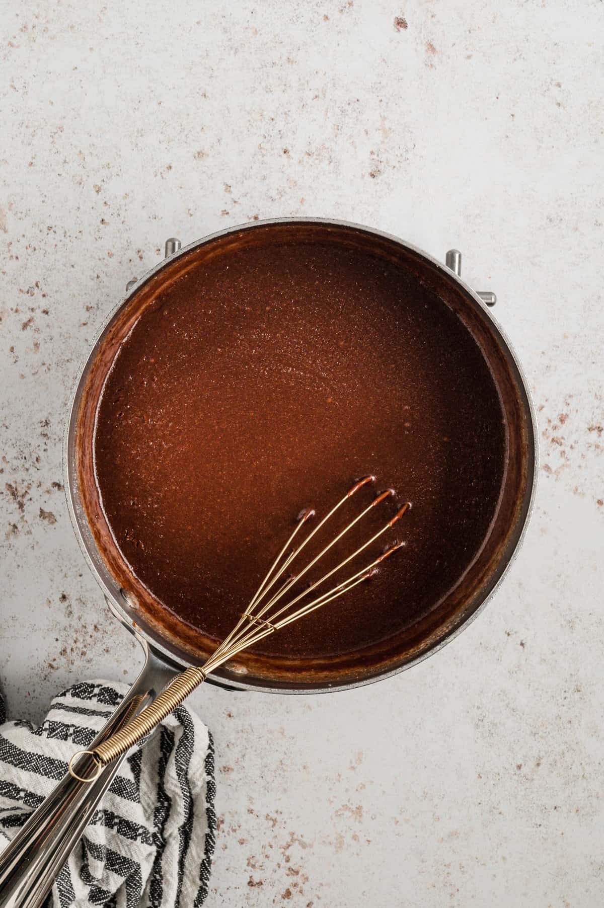 Whisking Chocolate Cherry Bars frosting in stovetop saucepan