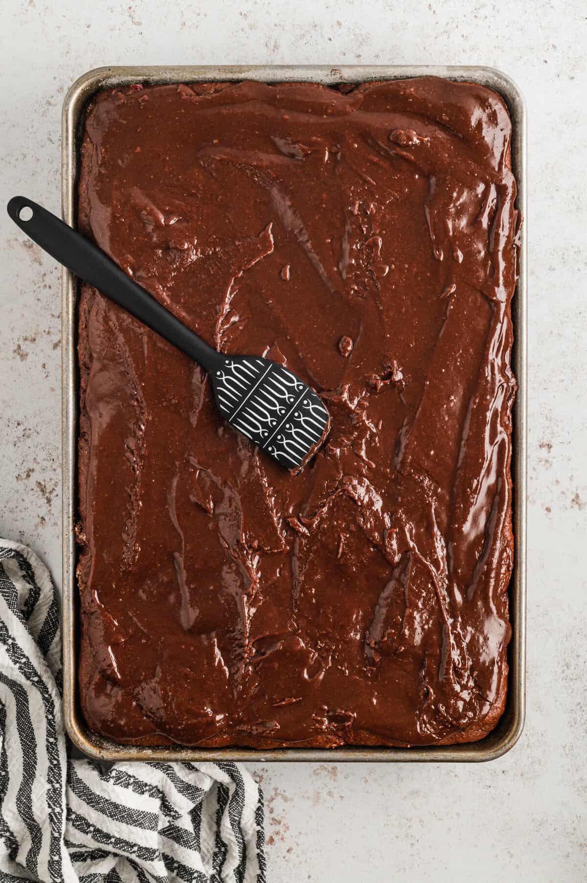 Using a spatula to spread frosting on Chocolate Cherry Bars