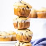 Stack of four chocolate chip muffins with blue napkin in background