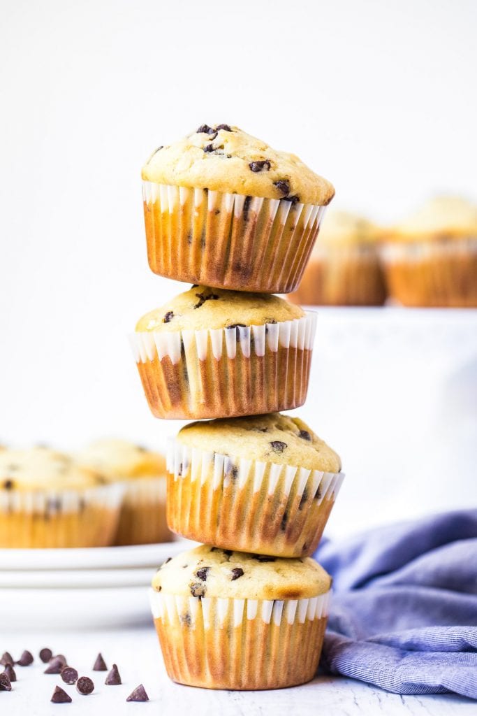Stack of four chocolate chip muffins with blue napkin in background