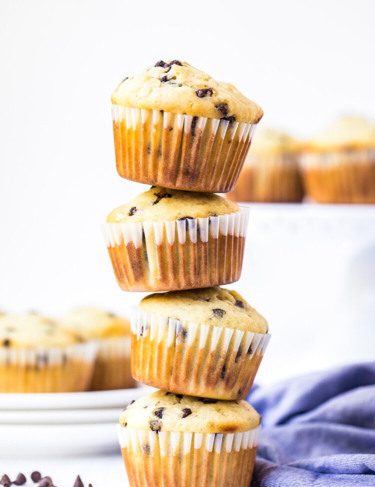 Stack of four chocolate chip muffins with blue napkin in background