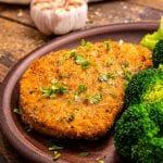 Plate with breaded pork chops and broccoli on it