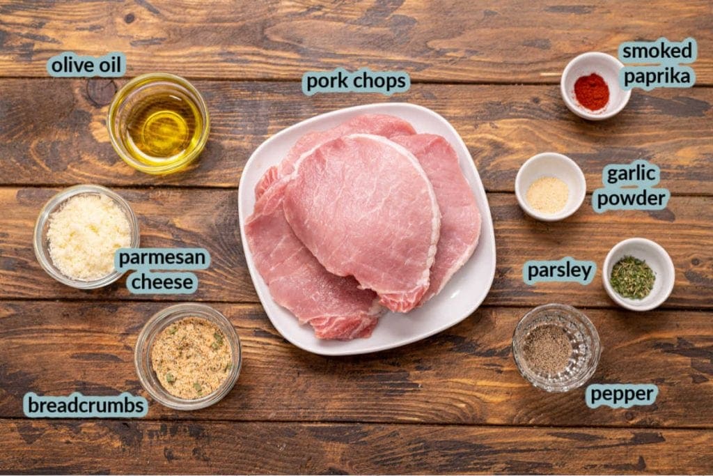 Ingredients for pork chops like pork chops olive oil breadcrumbs seasonings and parmesan cheese