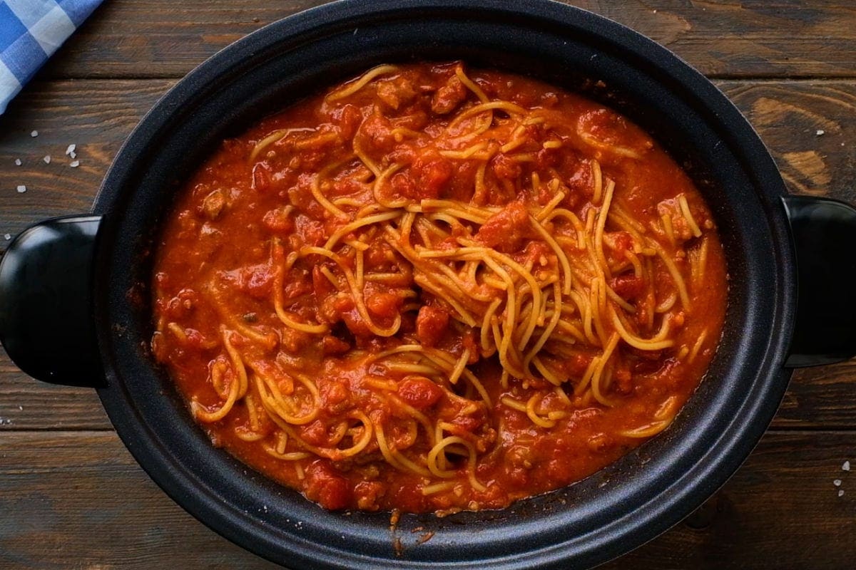 Overhead image of spaghetti in crock pot on wooden background