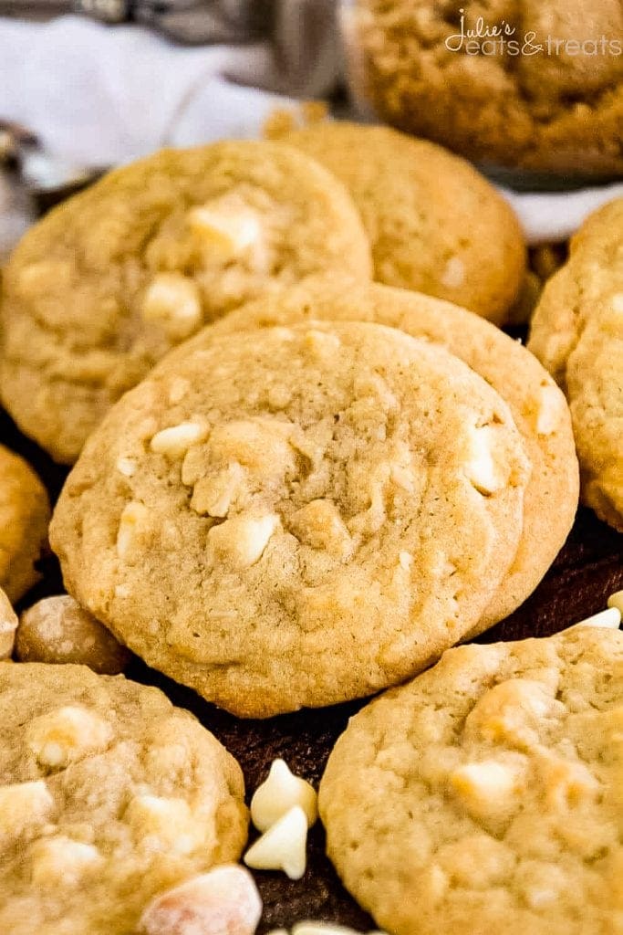 Cookies piled on their sides with more cookies and white chocolate chips next to them