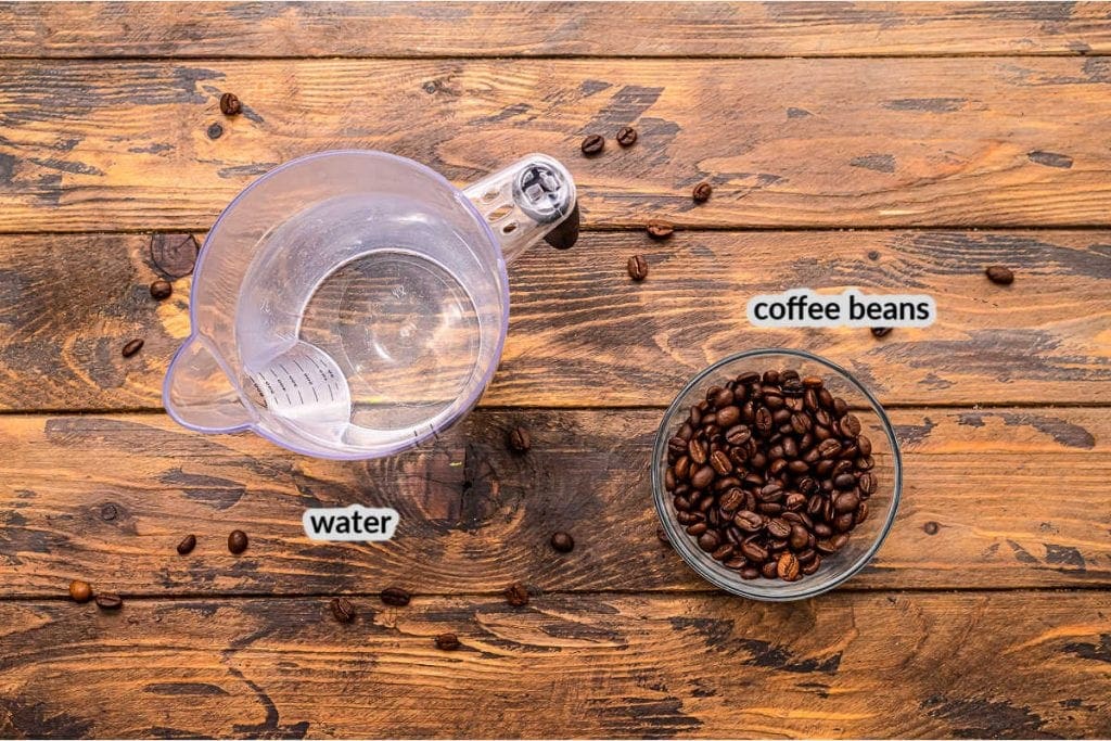 Wooden background with water in a measuring cup and coffee beans in a glass bowl