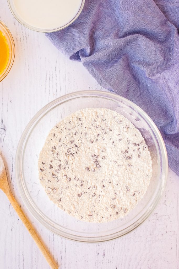 Dry ingredients combined in a glass bowl with blue napkin in background