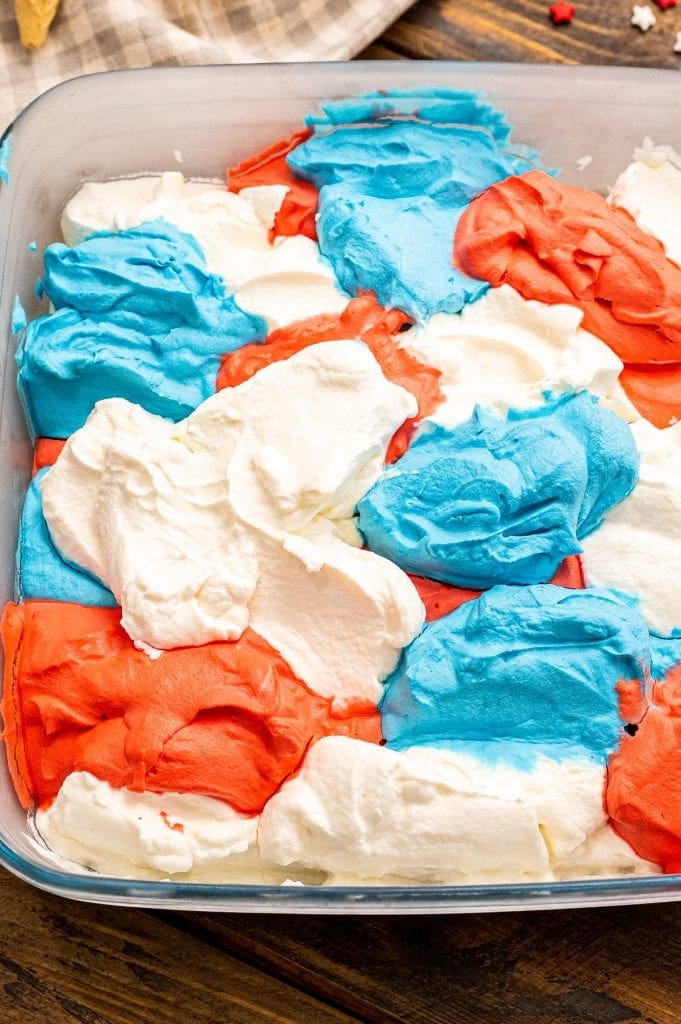 Red White and Blue Ice Cream dropped into a frosty square glass dish .