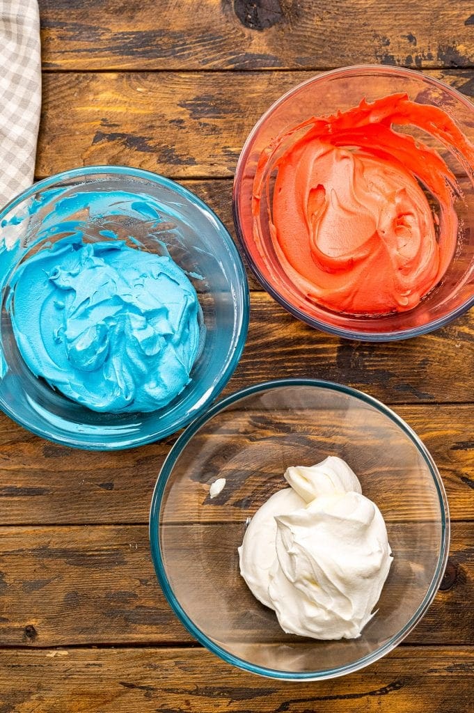 Three Glass bowls with red, white and blue ice cream mixture in them.