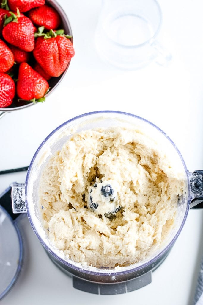 Biscuit dough in a food processor bowl after being mixed.