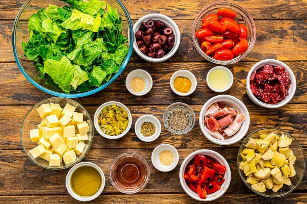 Overhead image of ingredients for Antipasto Salad in bowls.