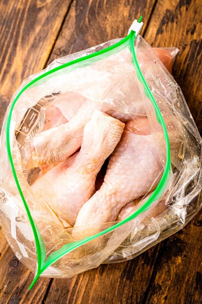 Resealable gallon bag with raw chicken drumsticks in it.