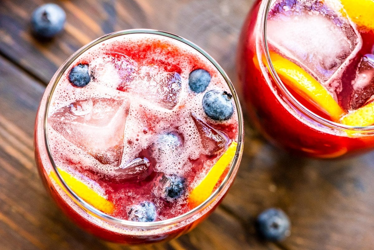 Overhead image of two glasses of fresh blueberry lemonade garnished with blueberries and lemon slices
