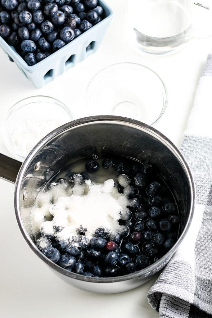 Saucepan with cooked blueberries and cornstarch mixture before stirring.