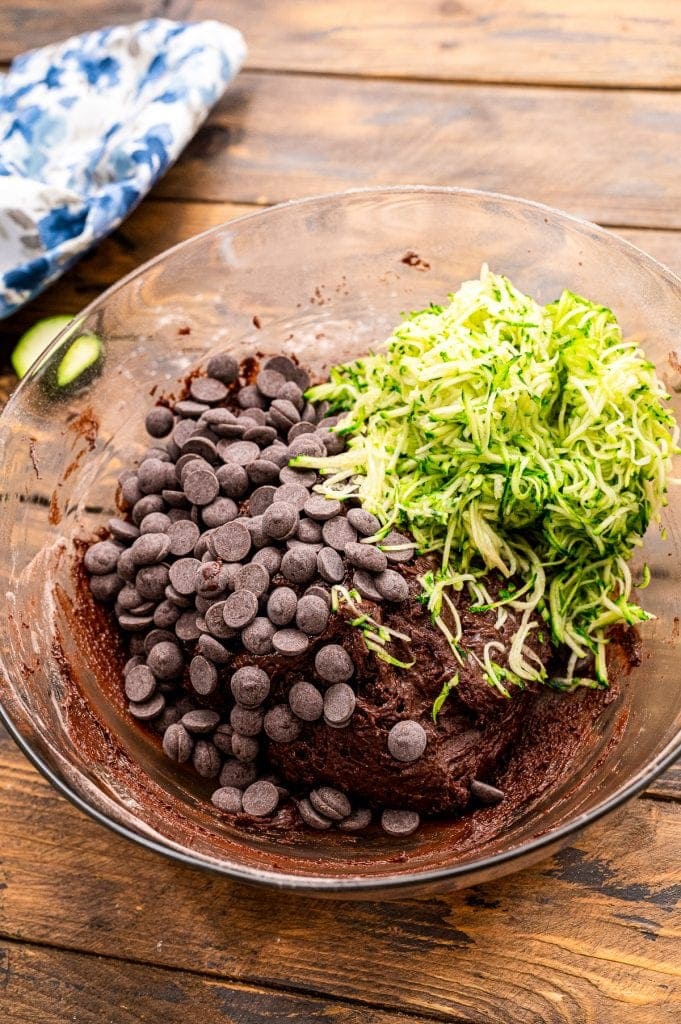 Batter mixed in bowl with chocolate chips and shredded zucchini on top.